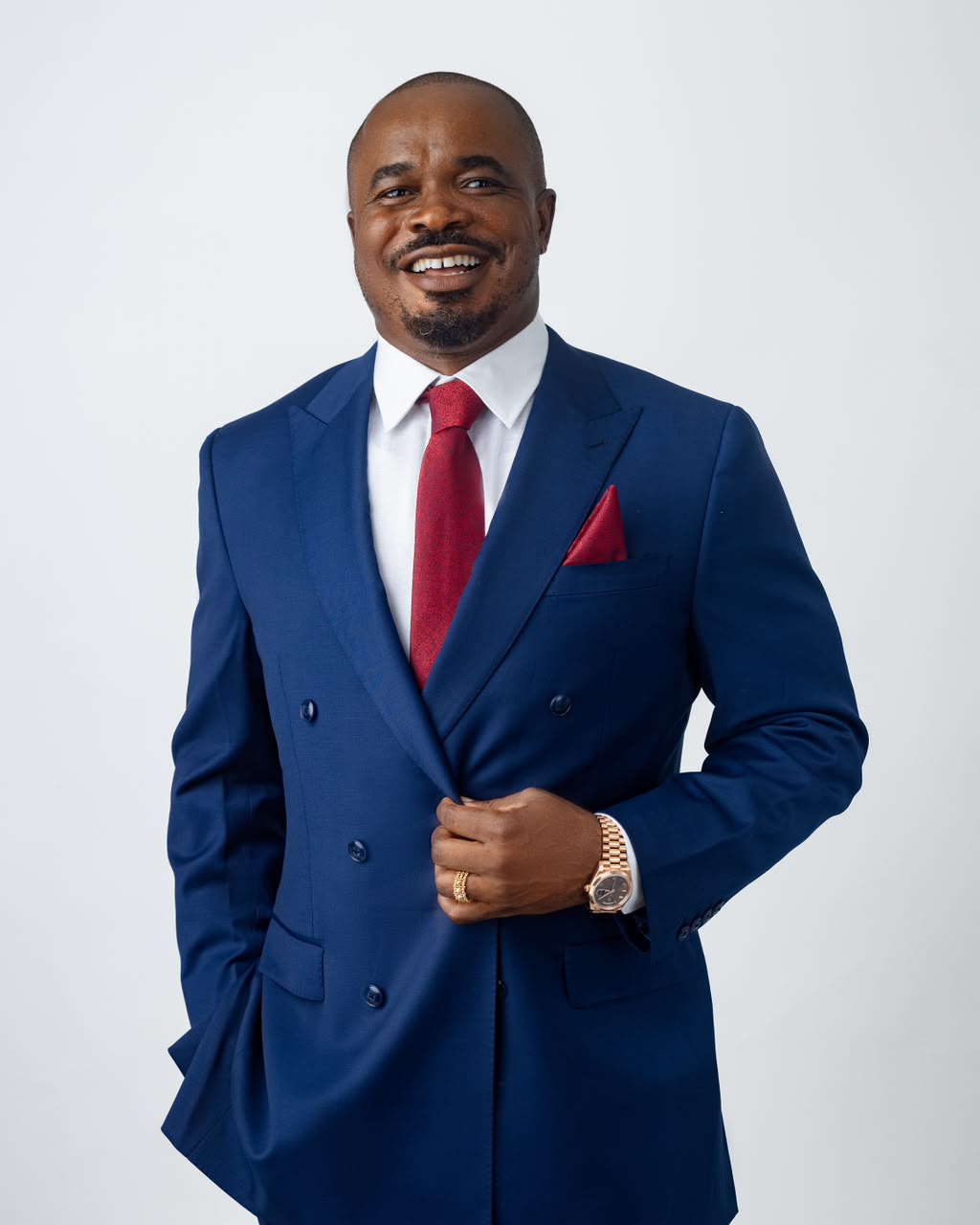 John Ifere in a navy double-breasted suit and red tie