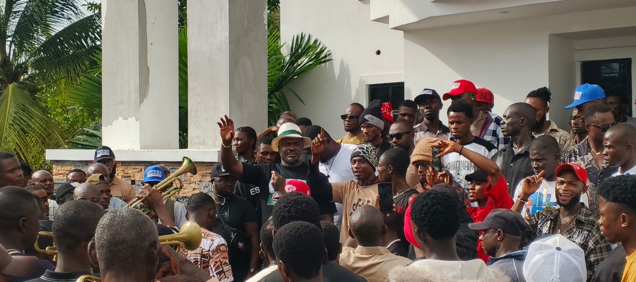John Ifere waving to a crowd of supporters